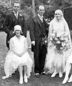 The woman to the far right is wearing a typical wedding dress from 1929. Until the late 1960s, wedding dresses reflected the styles of the day. From that time onward, wedding dresses have often been based on Victorian styles.